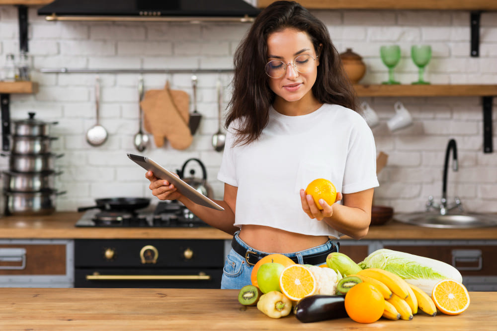 medium-shot-woman-with-tablet-looking-at-an-orange (1)