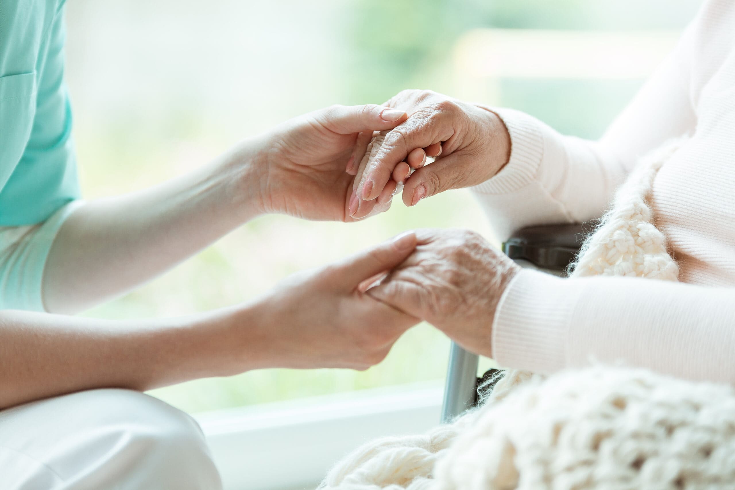 nurse-holding-patients-hands-PR65XXQ-scaled